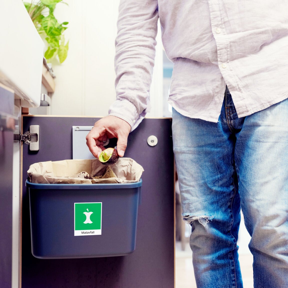 Har du dør under kjøkkenskapet, er en enkel og smart plassering av kildesorteringsdunk å henge den på døren.