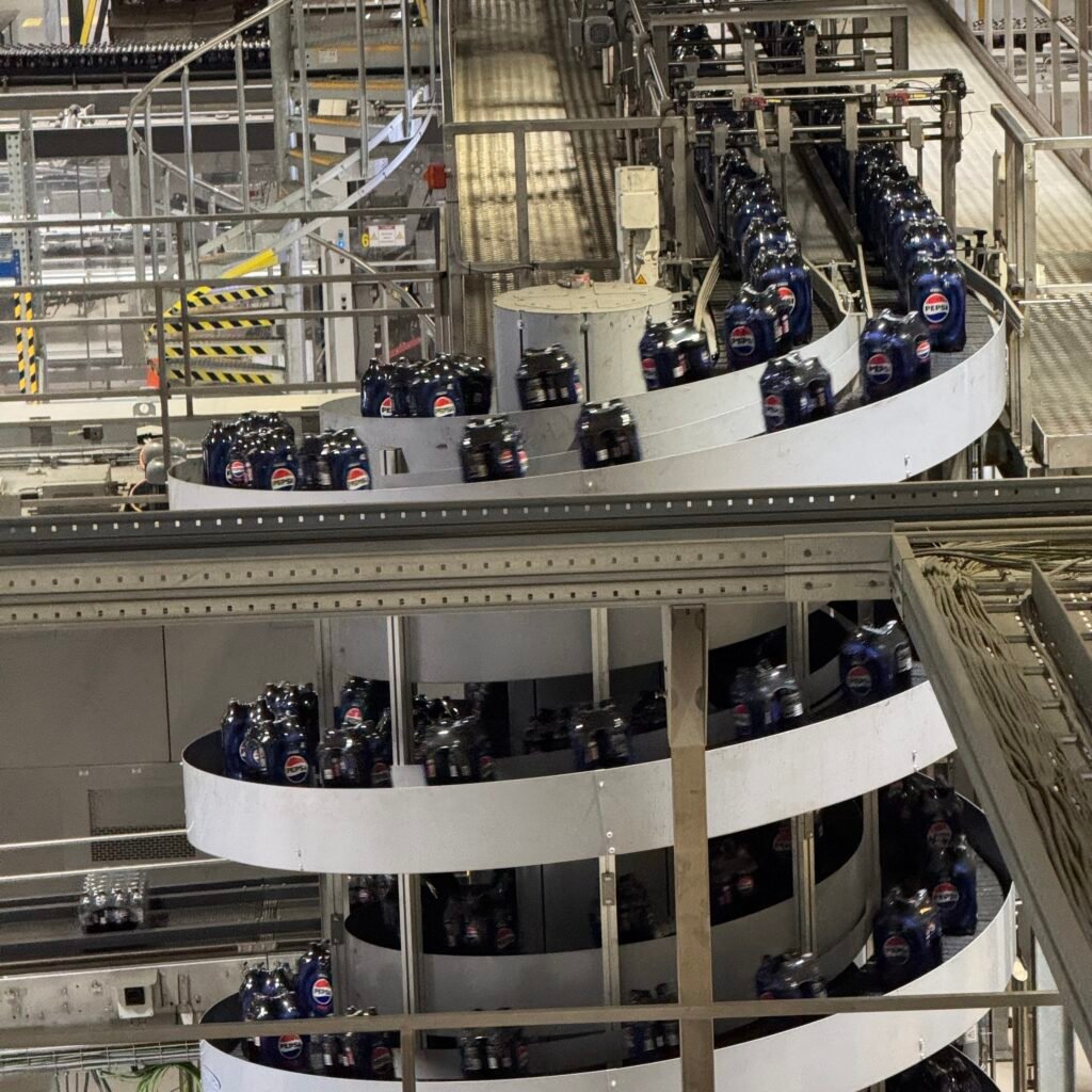 Panteflasker fylles med brus, og får på kork og etikett.
