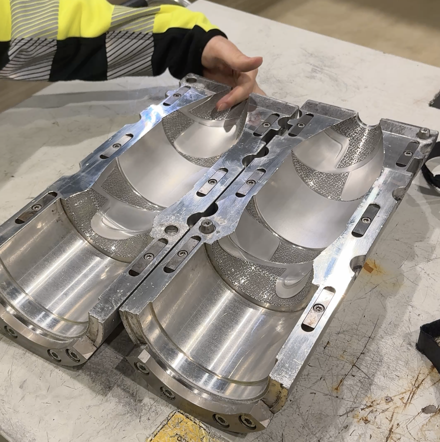 Preformer legges i en form og blir strekkblåst. Det brukes varme og trykkluft for å strekke og blåse preformene slik at de får ønsket brusflaskeform.