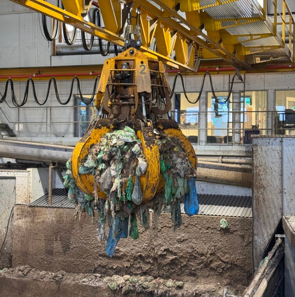Matavfallet blir løftet opp med en stor klo og matet inn i gjenvinningsanlegget.